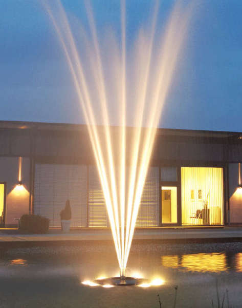 An OASE floating aerator fountain outdoors lighted up in the night time